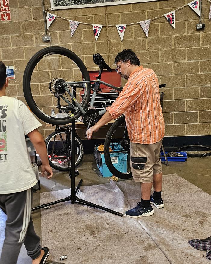 Volunteer repairing a bicycle on a repair stand